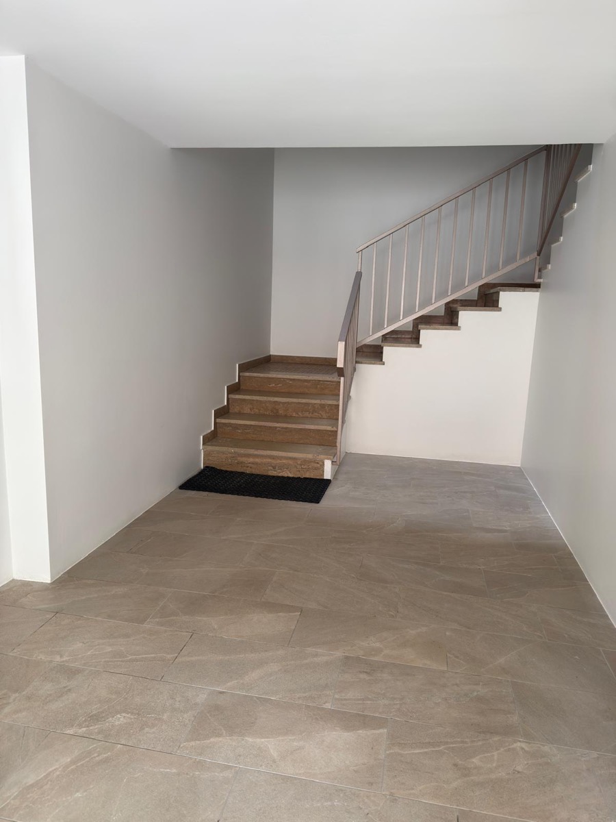 Ingresso con scala in pietra e ringhiera in metallo, pareti interne tinteggiate grigio chiaro