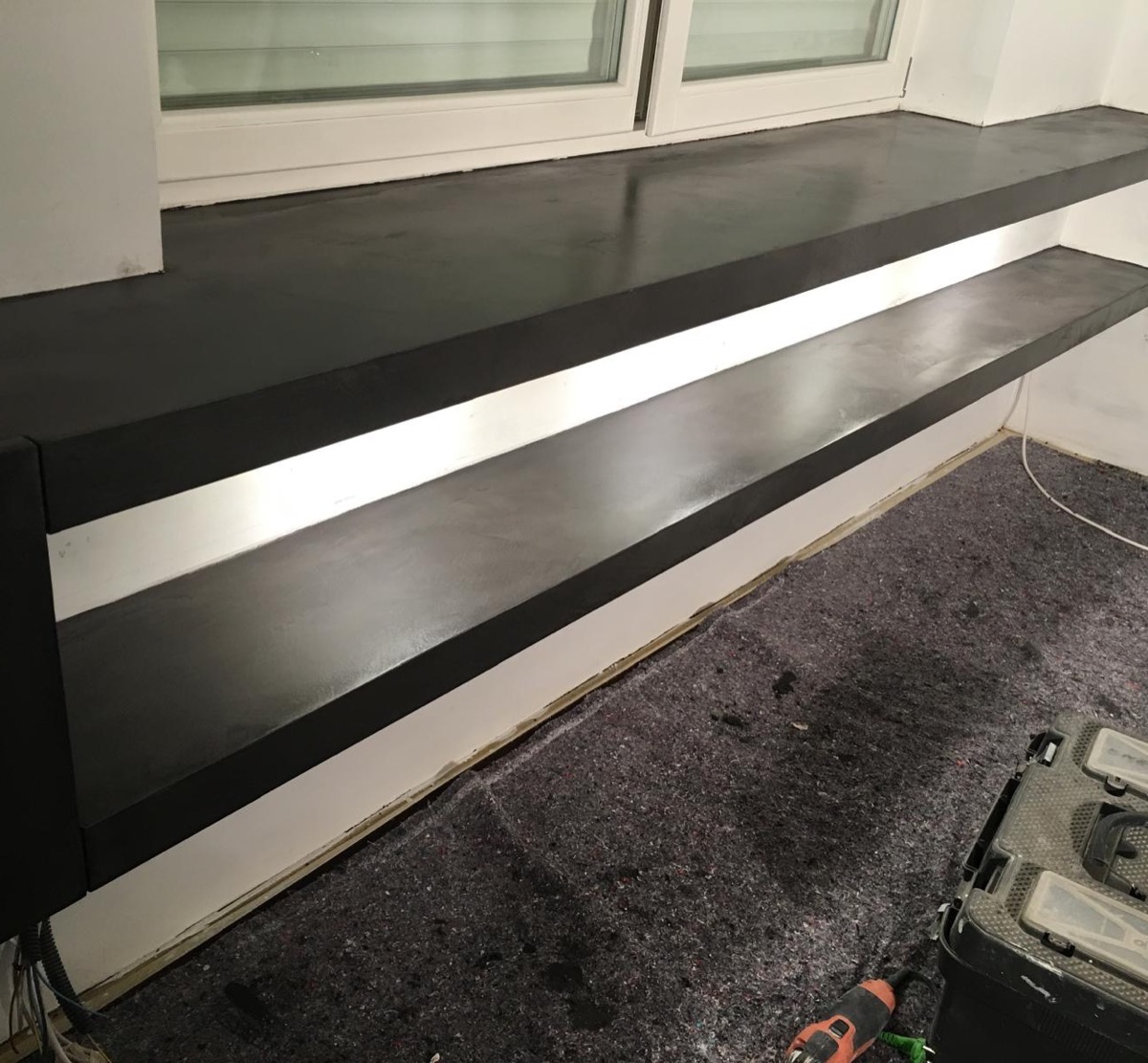Mensole passanti rifinite in resina grigio scuro con illuminazione LED lineare