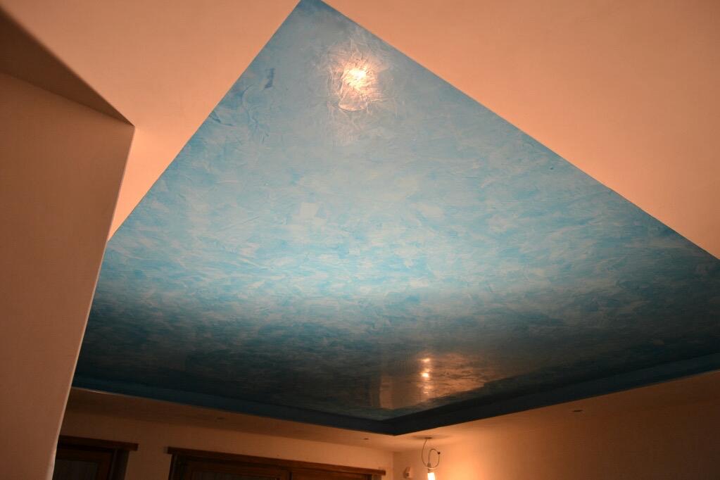 Soffitto ribassato decorato a effetto spatolato azzurro sopra un ambiente con pareti beige