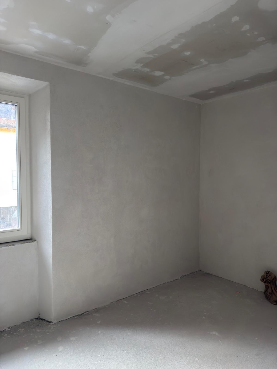 Stanza con pareti rasate e soffitto in cartongesso stuccato pronto per la tinteggiatura