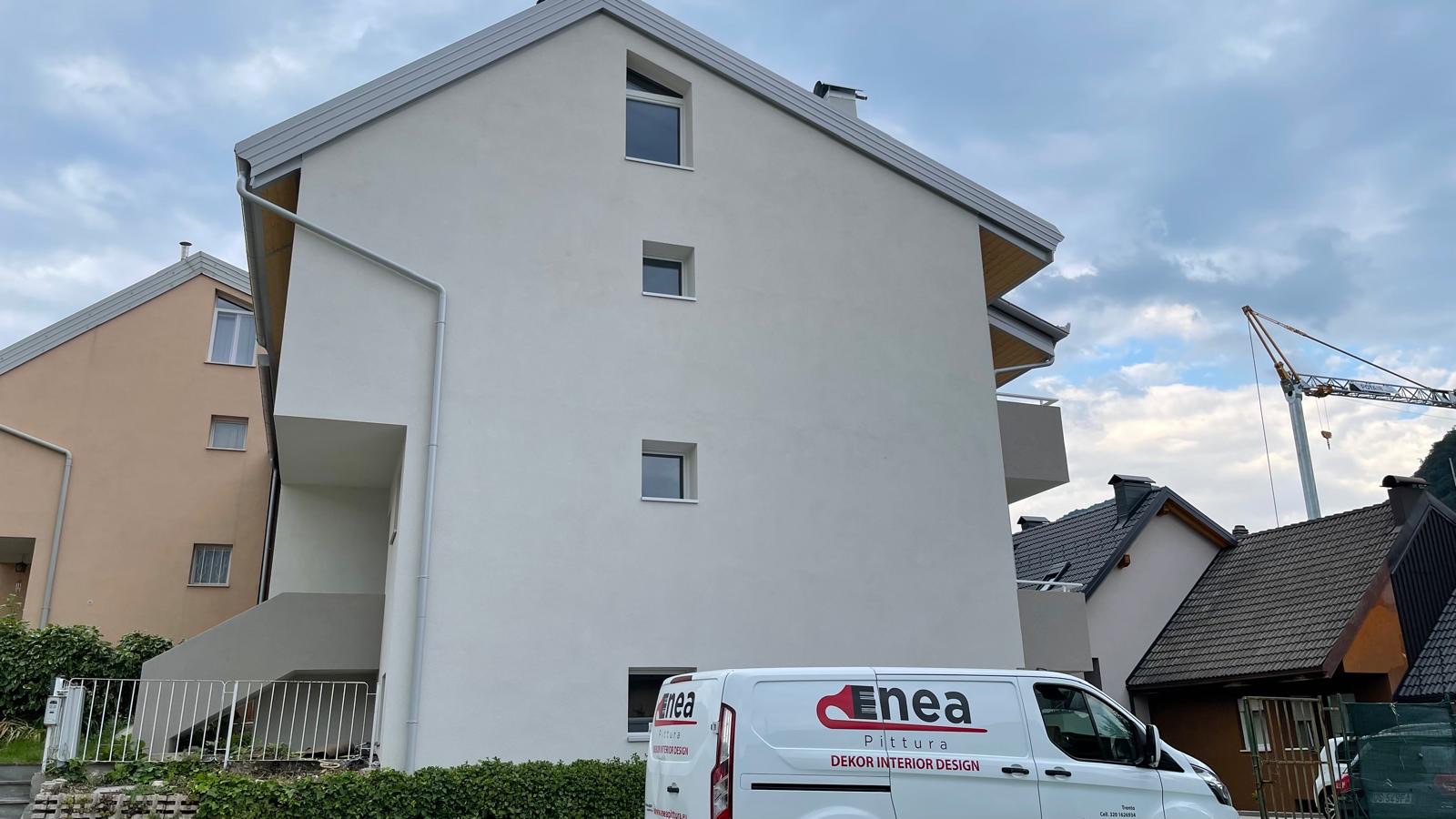 Palazzina con facciata bianca appena rifinita e furgone dell'impresa parcheggiato davanti