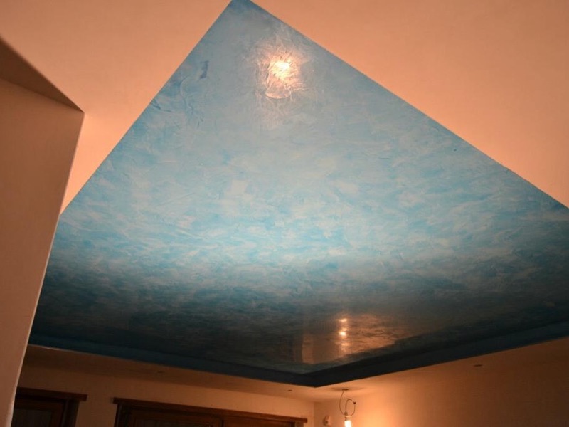 Soffitto ribassato decorato a effetto spatolato azzurro sopra un ambiente con pareti beige